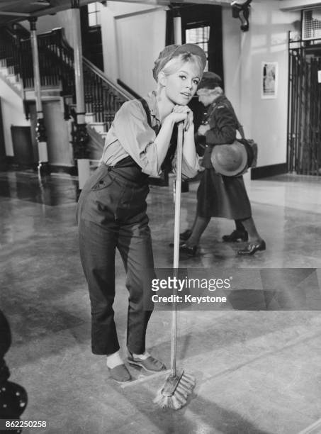 French actress Brigitte Bardot sweeps the floor of the Free French headquarters in a scene from the film 'Babette Goes To War', 20th January 1959.