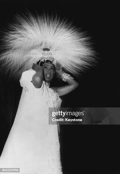 French entertainer Josephine Baker wears a headdress of 4,000 feathers for a rehearsal of her new revue 'Paris Mes Amours' at the Olympia Theatre in...