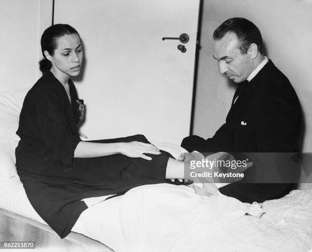 American choreographer George Balanchine checks on his wife Maria Tallchief , prima ballerina of the New York City Ballet, after she injured her...