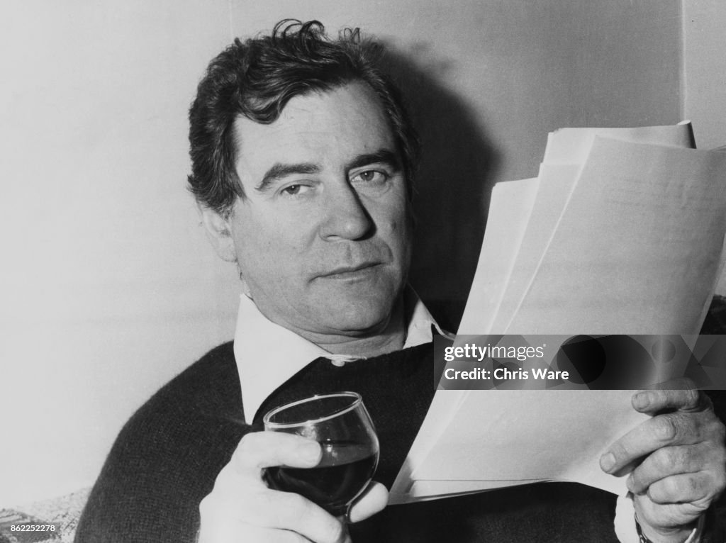 English actor Baker relaxes with a glass of wine at his home