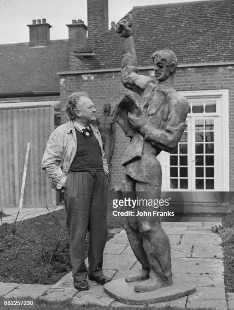 Austrian-born sculptor Siegfried Charoux with his new sculpture 'The Reader' at his studio in Golders Green, London, 21st March 1960. The sculpture...
