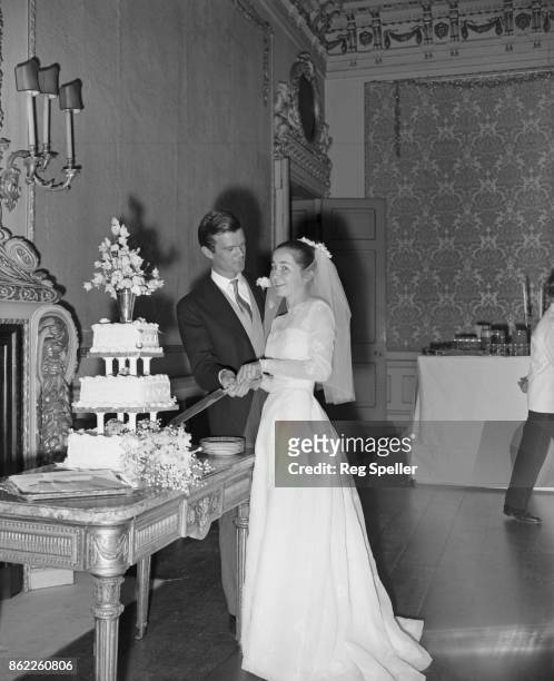 Alan Clark , the son of Arts Council chairman Kenneth Clark, cuts the cake with his new wife, 16-year-old Jane Beuttler, during their wedding...