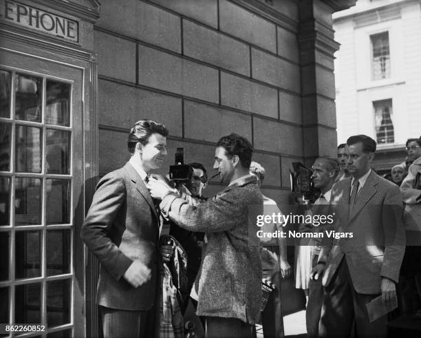 French director René Clément adjusts the tie of his leading man Gérard Philipe during the shooting of the Transcontinental Films production 'Monsieur...