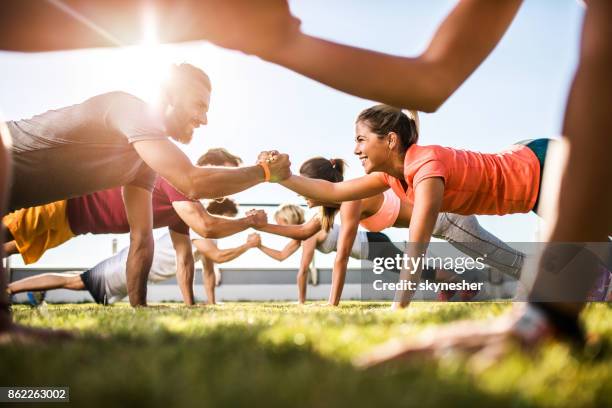 happy athletic people cooperating while exercising on a sports training. - competitive sport imagens e fotografias de stock