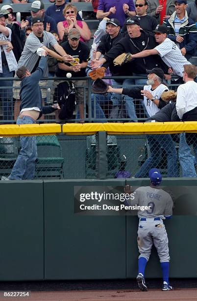 Left fielder Juan Pierre of the Los Angeles Dodgers watches from the warning track as fans scramble for a homerun ball hit by Ryan Spilborghs of the...