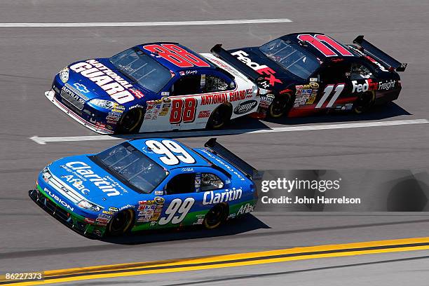 Carl Edwards, driver of the Claritin Ford, leads Dale Earnhardt Jr., driver of the National Guard / AMP Energy Chevrolet and Denny Hamlin, driver of...