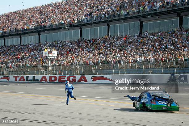 Carl Edwards, driver of the Claritin Ford, runs to the finish line after suffering damage at the conclusion of the NASCAR Sprint Cup Series Aaron's...