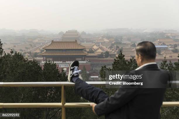 Man stretches his leg at Jingshan Park overlooking the Forbidden City in Beijing, China, on Tuesday, Oct. 17, 2017. President Xi Jinping is expected...
