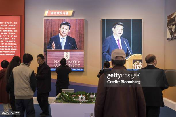 Attendees walk past photographs of Chinese President Xi Jinping on display at the "Five Years of Sheer Endeavor" show at the Beijing Exhibition...