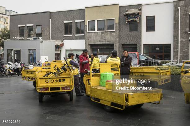 Delivery drivers for Ofo Inc. Bicycles stand with their trucks outside a subway station in Beijing, China, on Tuesday, Oct. 17, 2017. President Xi...