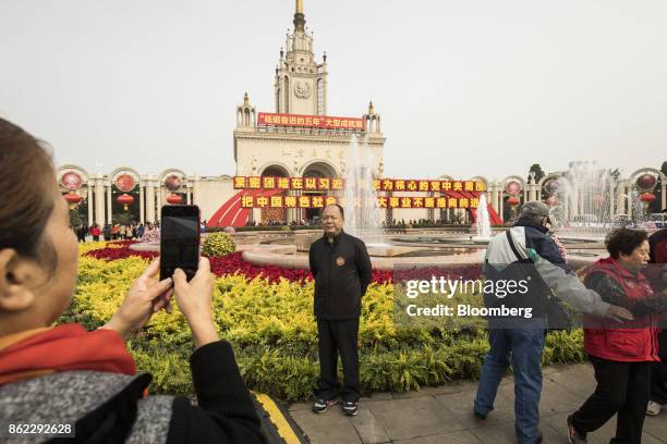 Man poses for a photograph outside the Beijing Exhibition Center showing the "Five Years of Sheer Endeavor" exhibition in Beijing, China, on Tuesday,...