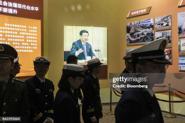 Members of the Chinese Liberation Army Navy walk past a photograph of Chinese President Xi Jinping on display at the "Five Years of Sheer Endeavor"...