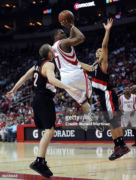 Guard Kyle Lowry of the Houston Rockets takes a shot against Brandon Roy and Steve Blake of the Portland Trail Blazers in Game Four of the Western...