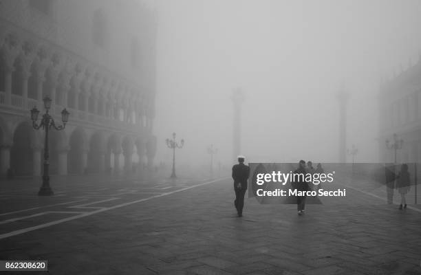 Policeman walks in Saint Mark's Square under heavy fog on October 17, 2017 in Venice, Italy. Venice and the lagoon woke up this morning under a heavy...