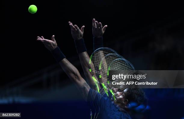 This multi-exposed picture shows Brazil's Rogerio Dutra Silva serving the ball to Russia's Evgeny Donskoy during their tennis match at the Kremlin...