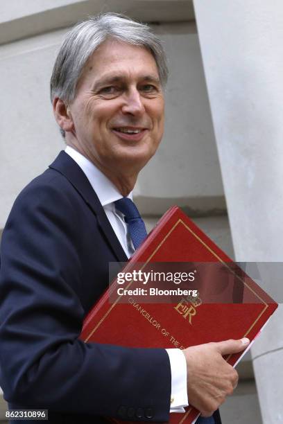 Philip Hammond, U.K. Chancellor of the exchequer, holds a document folder as he arrives at the treasury offices in London, U.K., on Tuesday, Oct. 17,...