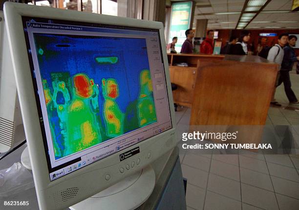 Images from a thermal imaging scanner are pictured on a computer screen as airplane passengers are screened for high temperatures upon arrival at...