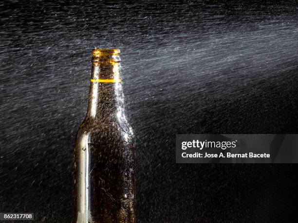 bottle of beer with the glass esmerilado with drops of water and a steam cloud frozen on a black bottom - beer mat stockfoto's en -beelden