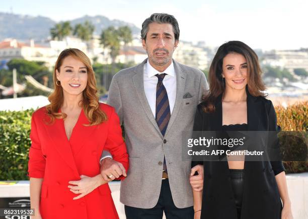 Turkish actors Dolunay Soysert, Erkan Petekkaya, Songul Oden poses during the International Market of Communications Programmes in Cannes, southern...