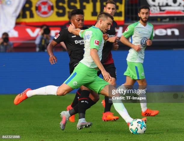 Ignacio Camacho of Wolfsburg and Leon Bailey of Leverkusen battle for the ball during the Bundesliga match between Bayer 04 Leverkusen and VfL...