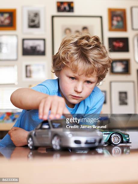 young boy aged five playing with toy cars - boy playing with cars stock pictures, royalty-free photos & images