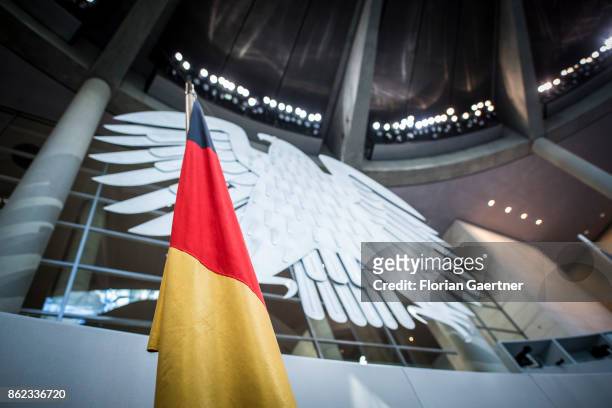 The German Flag is pictured in front of the Federal Eagle at the Reichstag on October 17, 2017 in Berlin, Germany. Following German federal elections...