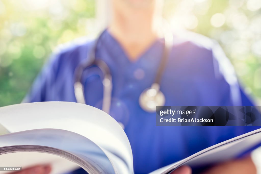 Doctor reading patient notes or medical chart