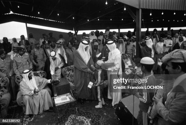 Le roi Khaled ben Abdelaziz al-Saoud avec Sheikh Zayed bin Sultan al-Nahyan et le prince Abdullah bin Abdulaziz al-Saud lors d'une course de chameaux...