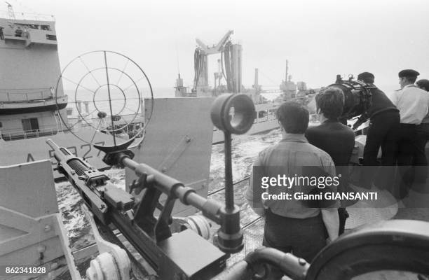 Marins échangeant des signaux lumineux sur le pont d'un navire lors de manoeuvres de l'OTAN en mer Méditerranée en octobre 1979, Italie.