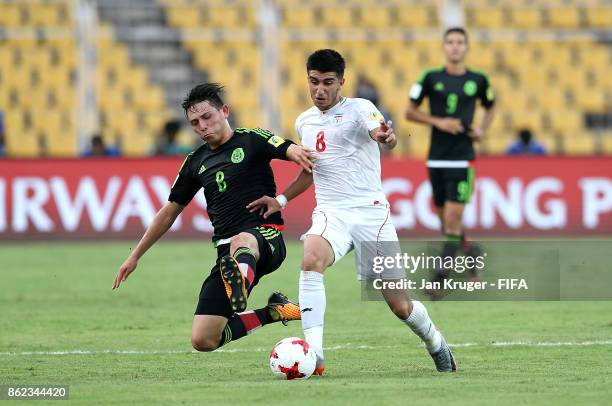 Mohammad Sharifi of Iran leaps over the tackle of Alexi Gutierrez of Mexico during the FIFA U-17 World Cup India 2017 Round of 16 match between Iran...