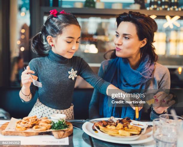mother and daughter in restaurant - eating french fries stock pictures, royalty-free photos & images