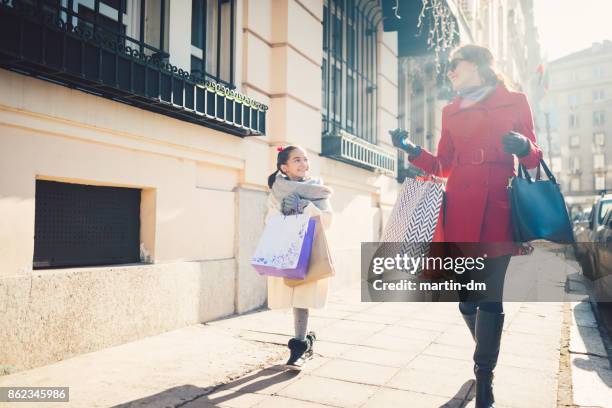 mädchen, die weihnachtsgeschenke einkaufen - kindertag stock-fotos und bilder