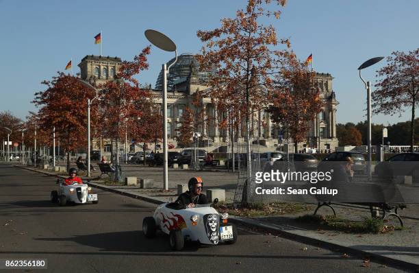 Mini hot rod drivers drive past the Reichstag, seat of the Bundestag, on October 17, 2017 in Berlin, Germany. Following German federal elections last...