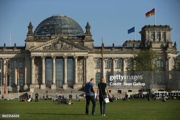 People relax on the lawn in front of the Reichstag, seat of the Bundestag, on October 17, 2017 in Berlin, Germany. Following German federal elections...