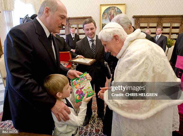 Nikolai, son of Belarus President Alexander Lukashenko offers a book to Pope Benedict XVI during their meeting in the Vatican on April 27, 2009. AFP...
