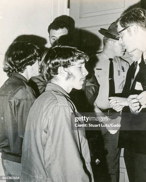 Students wearing hippie attire speak with sheriff's deputies in uniform during an anti Vietnam War student sit-in protest at North Carolina State...