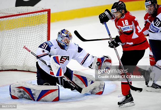 Goalkeeper Robert Esche holds the puck in front of Austria's Thomas Koch during their Group B preliminary round game, at the 2009 IIHF Ice Hockey...