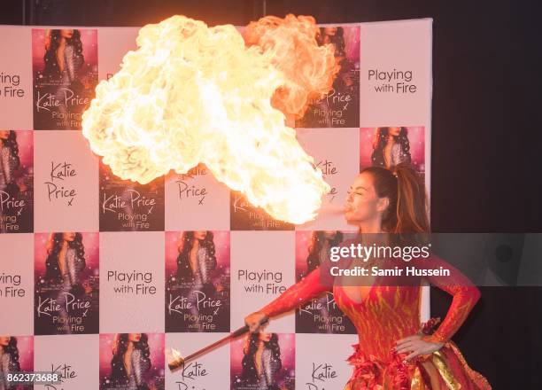 Katie Price blows fire during a photocall for her new novel 'Playing With Fire' at The Worx Studio's on October 17, 2017 in London, England.