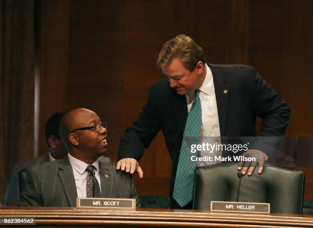 Sen. Tim Scott talks with Sen. Dean Heller during a Senate Banking, Housing and Urban Affairs Committee hearing on "Consumer Data Security and the...