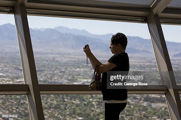 Woman takes pictures of the city below from the observation tower atop the Stratosphere Hotel & Casino as viewed in this 2009 Las Vegas, Nevada, late...