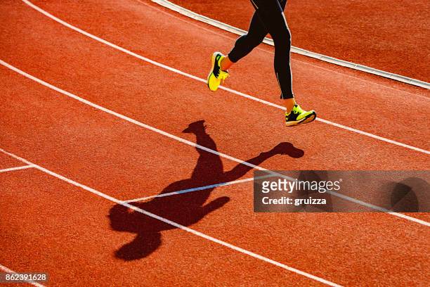 sportler, die über die laufstrecke - running shadow stock-fotos und bilder