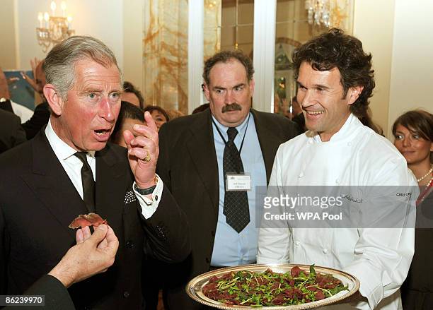 Prince Charles, Prince of Wales tries some beef prepared by chef Carlo Cracco during an organic food reception at the British Ambassador's residence...