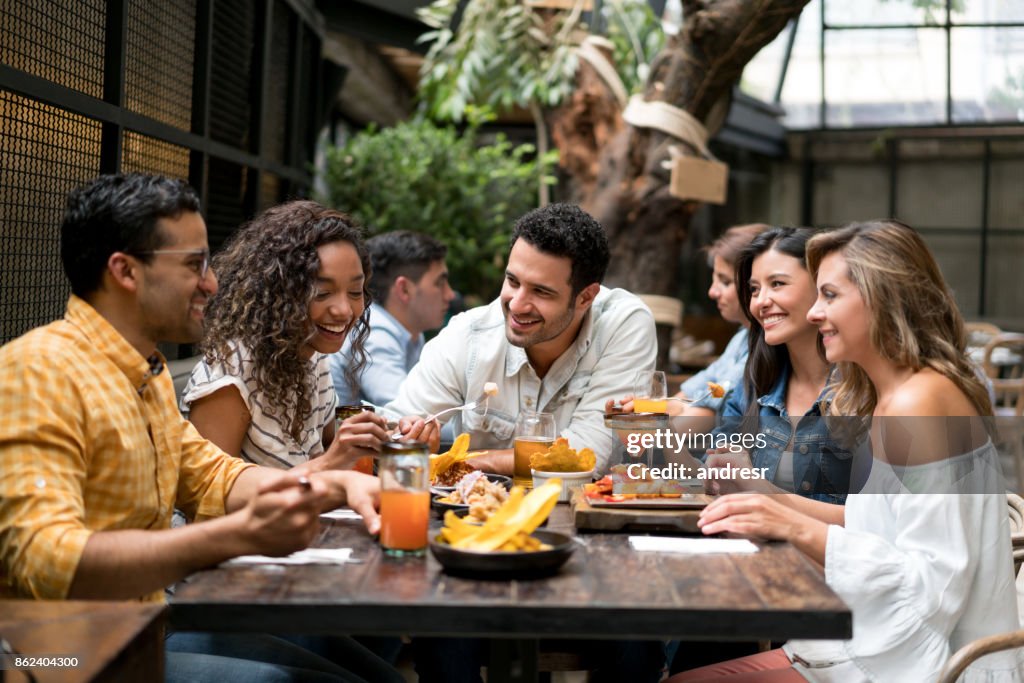 Happpy group of friends having dinner together at a restaurant