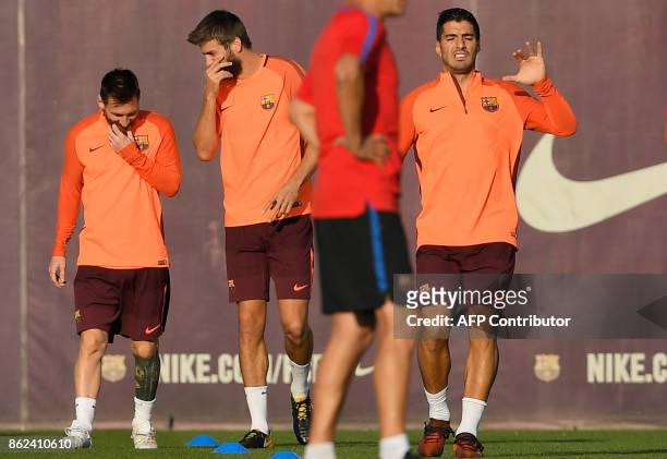 Barcelona's Argentinian forward Lionel Messi , Barcelona's defender Gerard Pique and Barcelona's Uruguayan forward Luis Suarez take part in a...