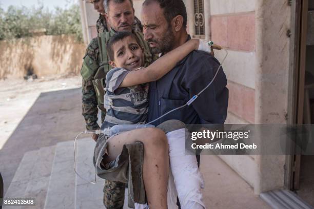 Syrian man holds his child who was injured by a mine which exploded when a group of civilians were escaping the Islamic State controlled areas of...