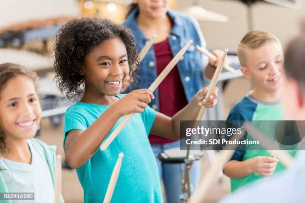 scholieren leren percussie-instrumenten te bespelen - drumstok stockfoto's en -beelden