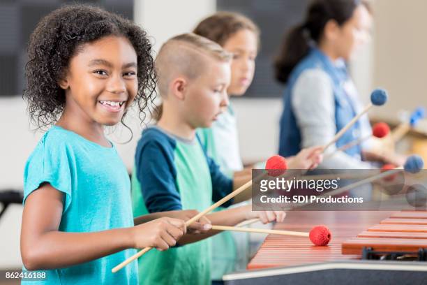 cheerful african american schoolgirl plays marimba - moving train hits students stock pictures, royalty-free photos & images