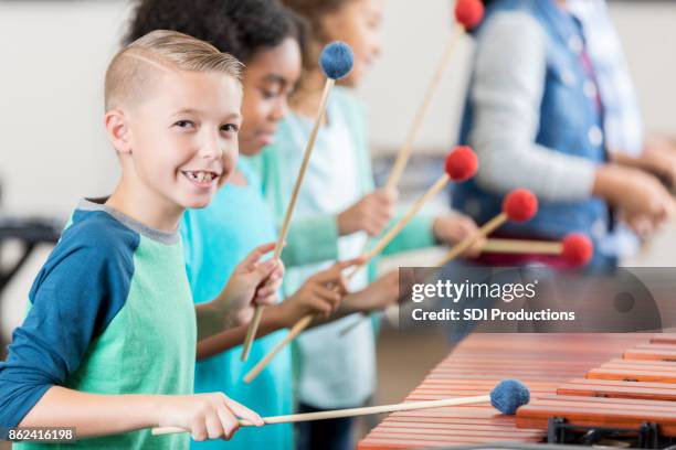 handsome schoolboy plays marimba during percussion class - moving train hits students stock pictures, royalty-free photos & images