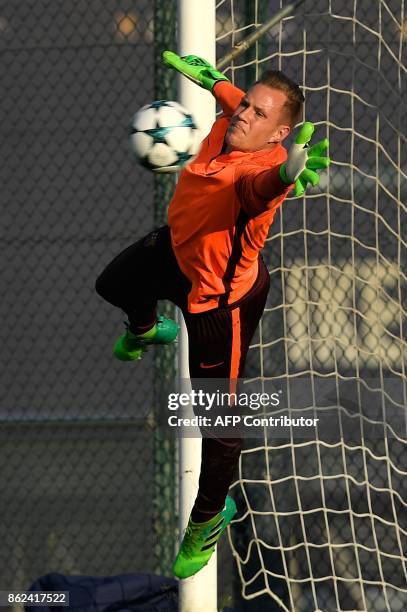 Barcelona's German goalkeeper Marc-Andre Ter Stegen dives for the ball during a training session at the Joan Gamper Sports Center in Sant Joan Despi,...