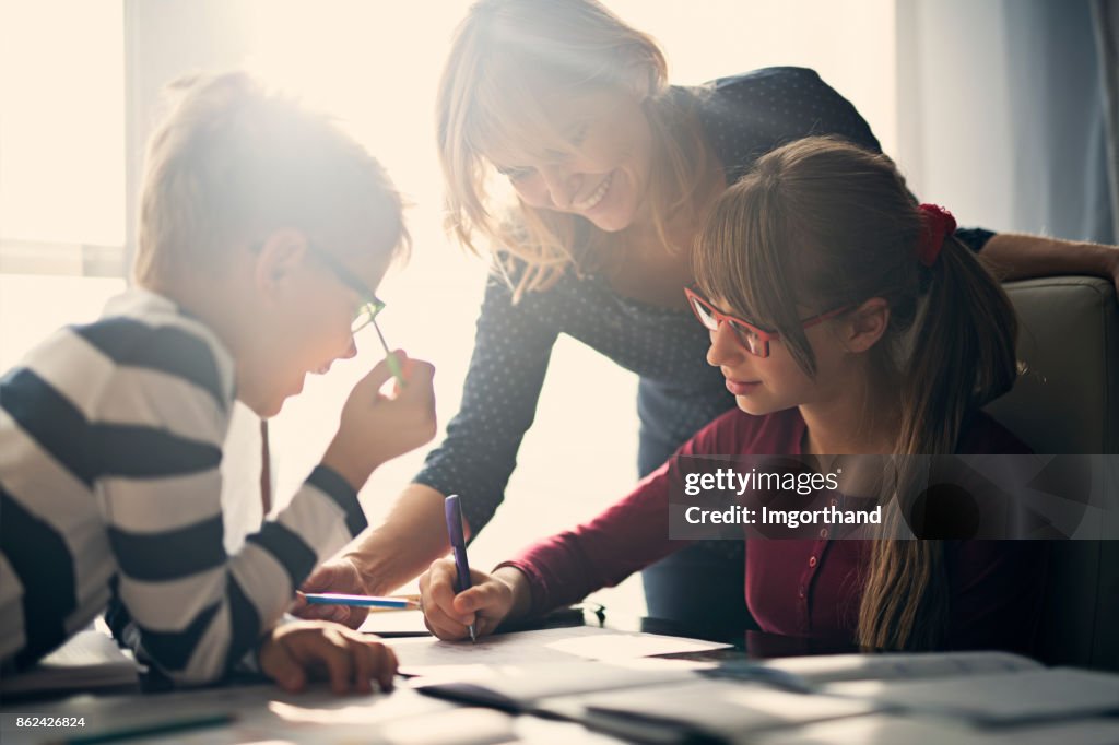 Moeder halping kinderen om huiswerk te doen